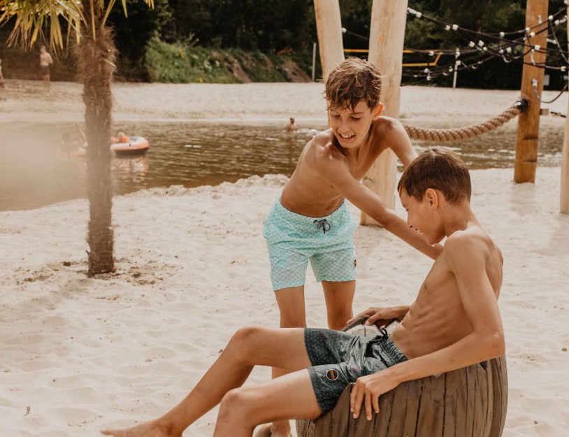 Camping-de-kleine-wolf-faciliteit-zandstrand-speeltoestel-kokosnoot-jongens-zijkant.jpg