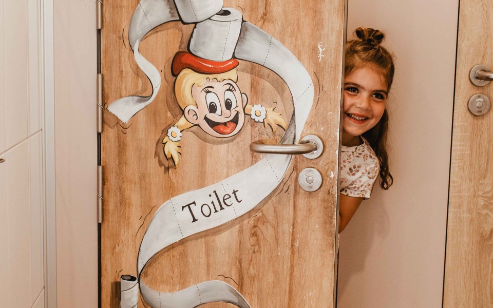 Camping-de-kleine-wolf-faciliteit-toiletgebouw-kindertoilet-meisje-deur.jpg