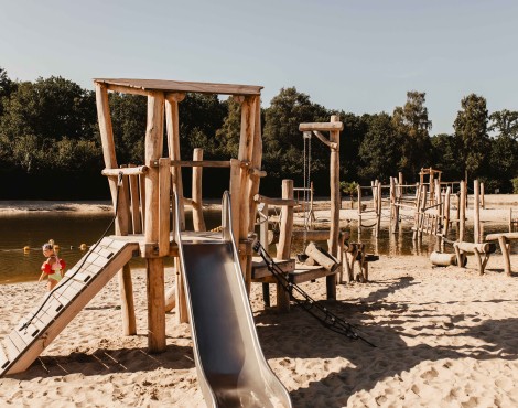 Camping-de-kleine-wolf-faciliteit-zandstrand-speeltoestel.jpg