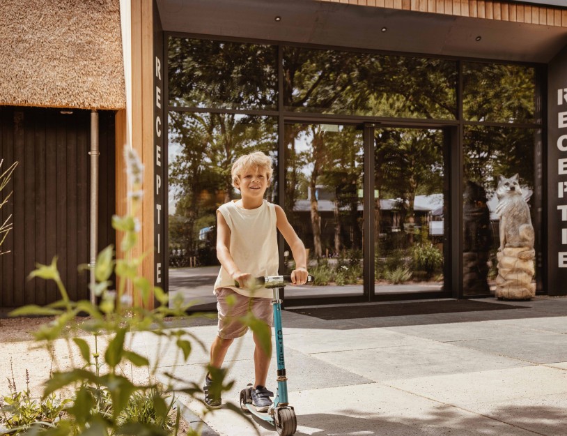 Camping-de-kleine-wolf-faciliteit-entree-receptie-jongen-step.jpg
