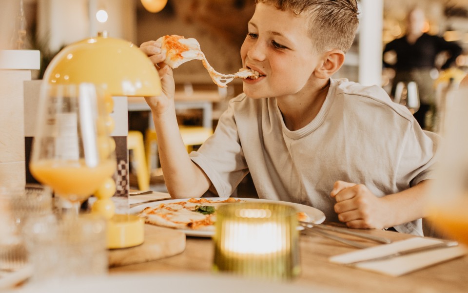 Camping-de-kleine-wolf-italiaan-pizza-eten-jongen-lachen-2.jpg