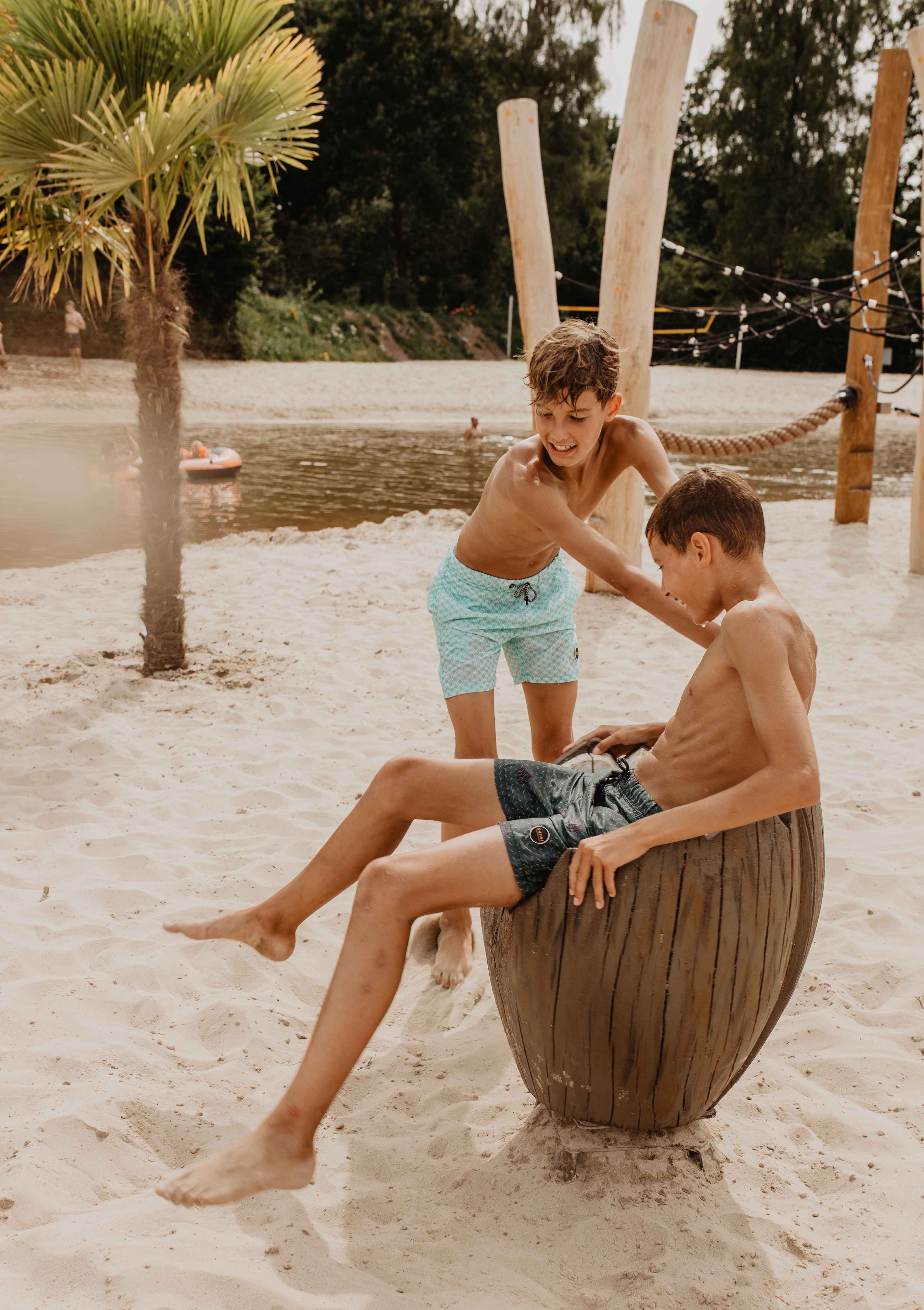 Camping-de-kleine-wolf-faciliteit-zandstrand-speeltoestel-kokosnoot-jongens-zijkant.jpg
